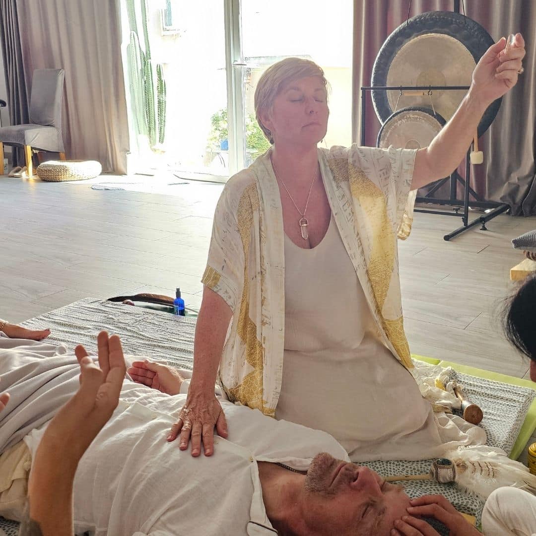 Sue Holmes completing a healing session with someone lay down next to her