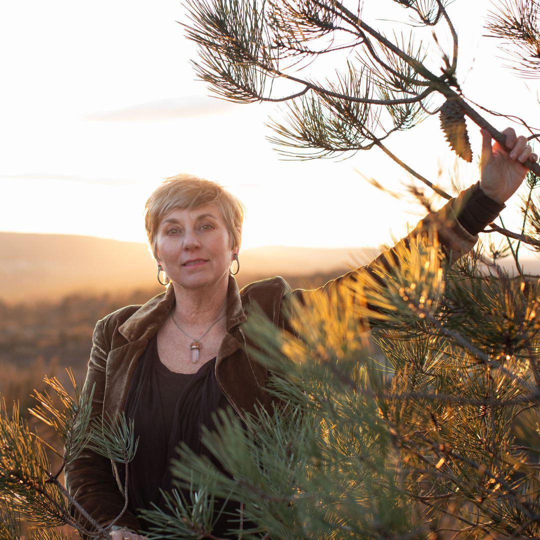 user_assets_7GG911JD_uploads_images_image-1-intro---1-1-1771323933 Sue Holmes completing a healing session with someone lay down next to her